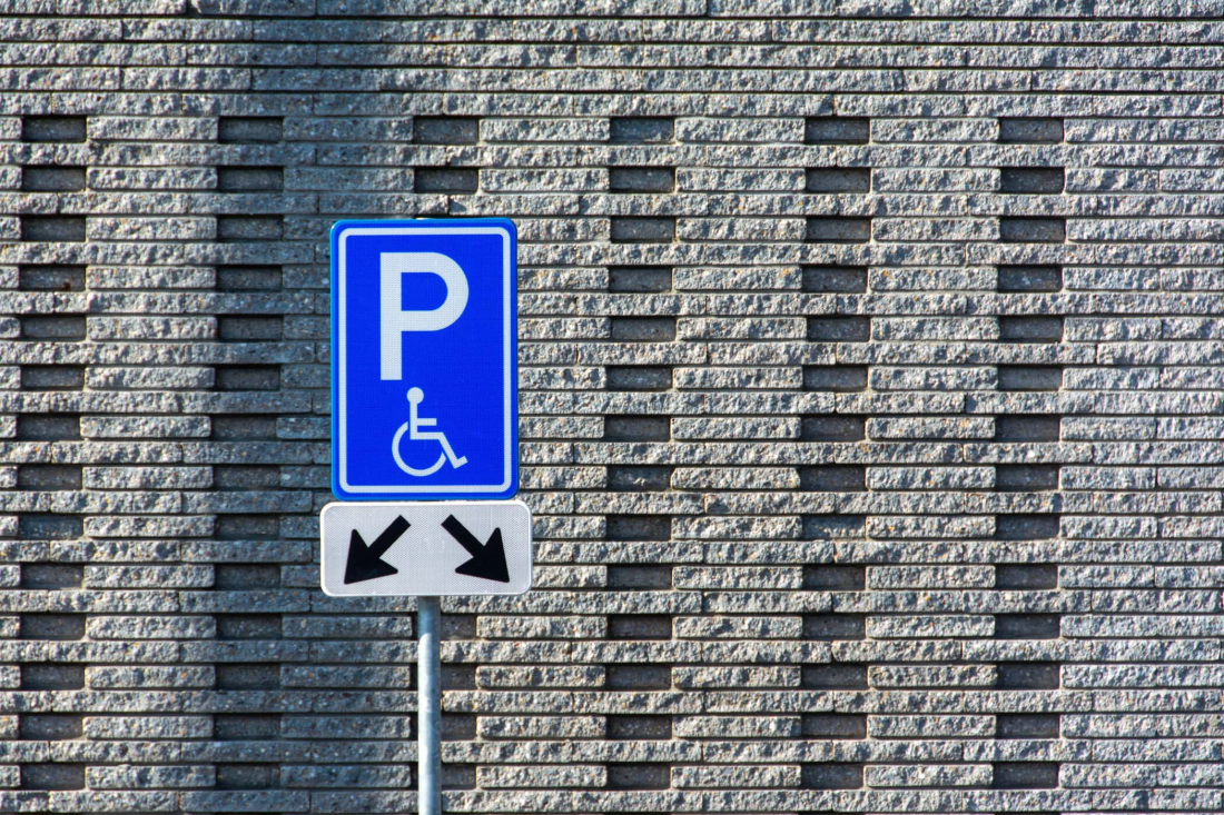 Parkeerplaats voor gehandicapten met blauwe en witte symbolen.